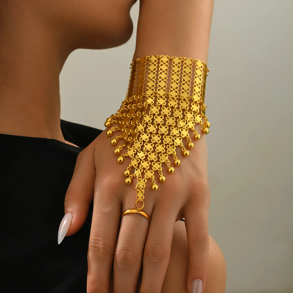 A Golden Retro Court-Style Hollow Geometric-Shaped Small Ball Pendant For A Dance Performance Paired With A Finger Bracelet.