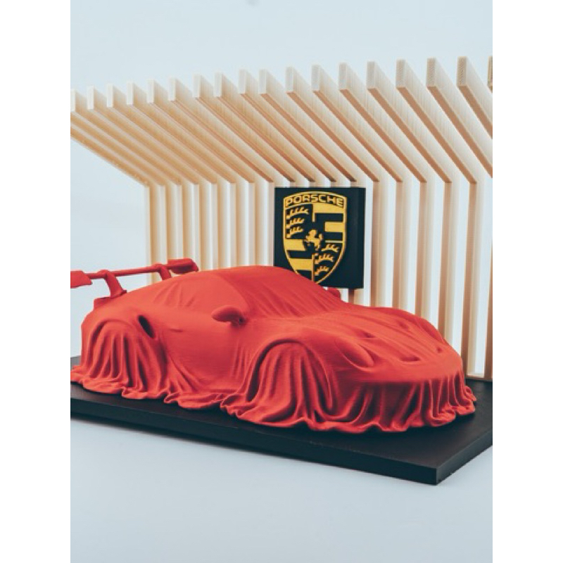 Impressão 3D | Porshe 911 GT3 RS coberto em um suporte de exibição.